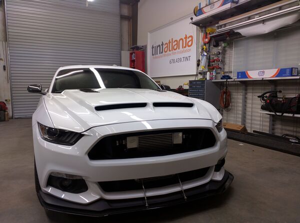 Ford Mustang GT front view showing professional dark window tint by Tint Macon