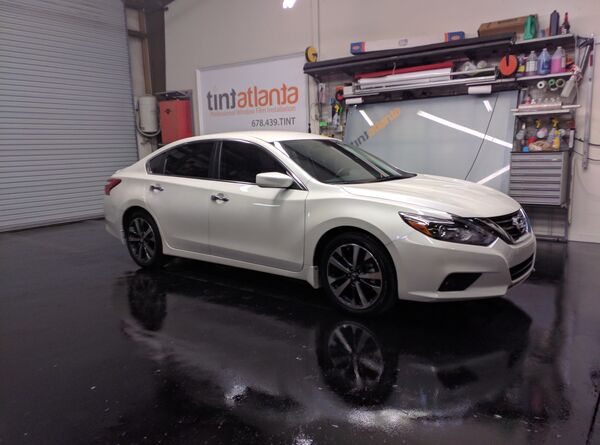 White Nissan Altima sedan with window tint installation Tint Macon
