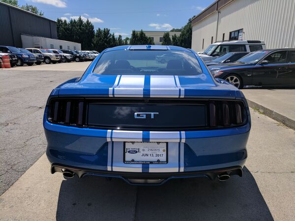 Blue Ford Mustang GT with racing stripes and tinted windows Macon